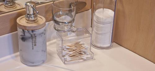 a counter top with two glass vases and a bottle of water at Suite Majorelle du Château in Gaillan-en-Médoc