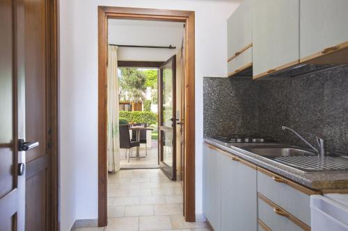 a kitchen with a sink and a door leading to a patio at Cormoran Residence in Villasimius
