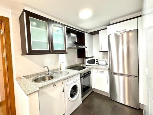 a small kitchen with a sink and a dishwasher at Alice House in Miño