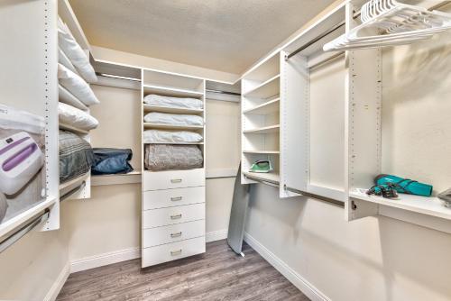 a walk in closet with white cabinets and drawers at Vila Sol in Las Vegas