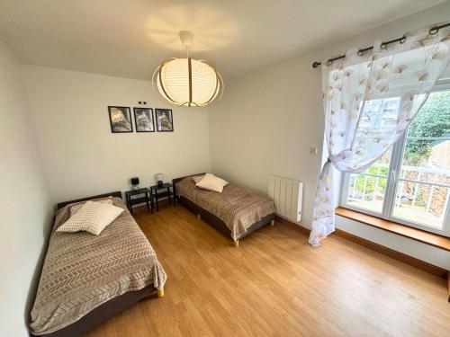 a bedroom with two beds and a large window at Maison Centre Ville - Saint-James in Saint-James