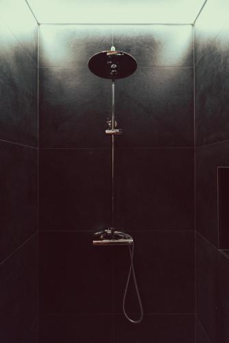 a shower with a light in a black tiled bathroom at Domus Due in Ravenna