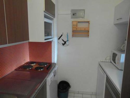 eine kleine Küche mit einem Herd und einem weißen Kühlschrank in der Unterkunft Appartement cosy au Praz de Lys pour 6 pers, près des pistes, 2 pièces - FR-1-815-20 in Le Praz de Lys