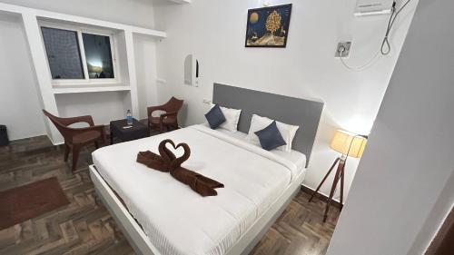 a bedroom with a bed with a brown ribbon on it at The Base Inn in Puducherry
