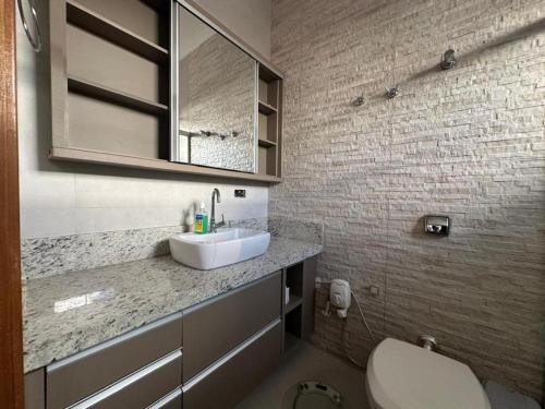 a bathroom with a sink and a toilet at Casa Munique Maringa in Maringá