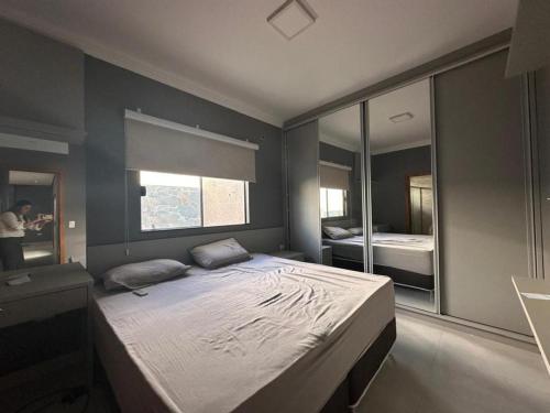 a bedroom with a large bed and a mirror at Casa Munique Maringa in Maringá