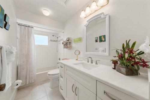 a white bathroom with a sink and a toilet at The Turtle Nest in Sanibel