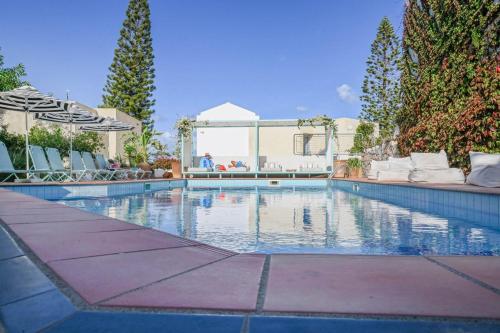 een groot zwembad met stoelen en bomen bij Villa Iokasti in Chersonissos