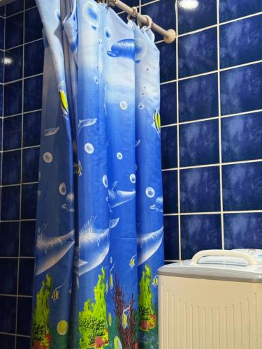 a bathroom with a blue shower curtain with fish on it at Elabd Family Porto Chalet in Marsa Matruh