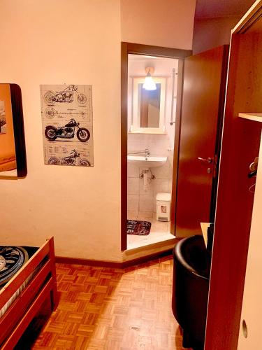 a room with a bathroom with a motorcycle on the wall at Albergo della Posta in Clusone