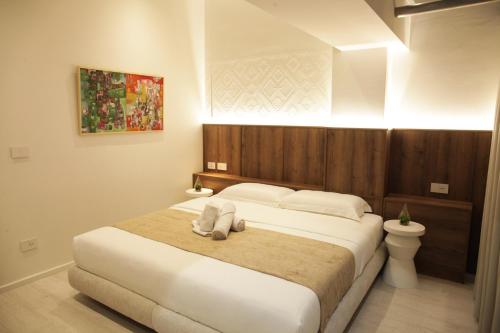 a bedroom with a large bed with a wooden headboard at A Gallery Hotel in Shkodër