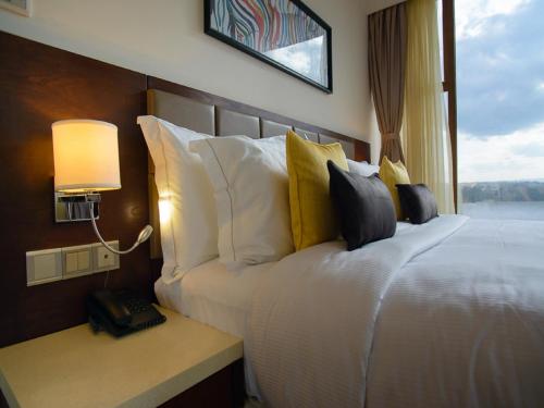 a hotel room with a bed with a window at The Concord Hotel & Suites in Nairobi