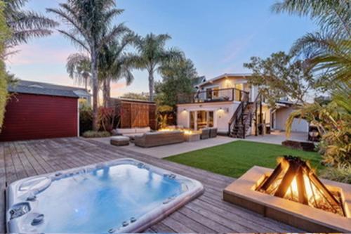 a house with a large hot tub in a yard at Pleasure Point Surf Retreat in Santa Cruz
