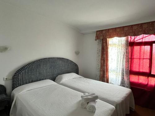 a bedroom with two beds with white sheets and a window at Hostal Chocolate & Menta Redondela in Redondela