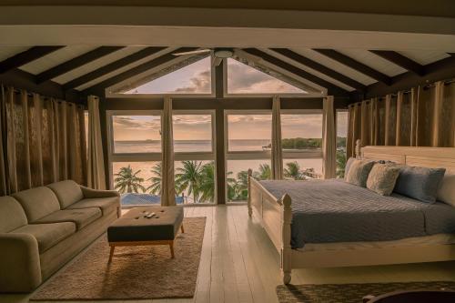 Un dormitorio con una cama y vista al mar. en West end inn, en Roatan