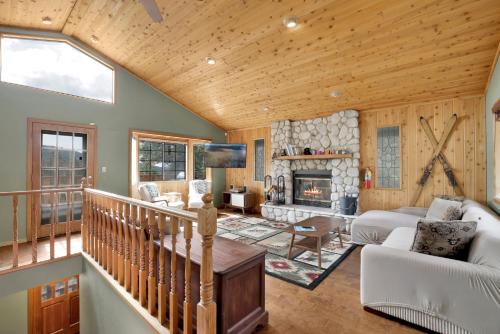 a living room with a staircase and a fireplace at Moonridge Treehouse #2570 in Big Bear Lake