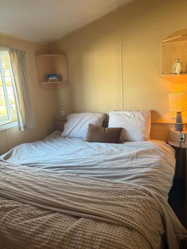 ein Schlafzimmer mit einem großen Bett mit weißer Bettwäsche in der Unterkunft Prachtig chalet op Camping It Wiid in Earnewâld