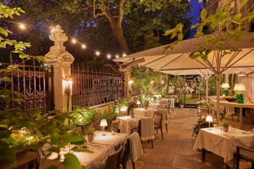 a row of tables with white tablecloths and lights at The Royal Horseguards Hotel, London in London