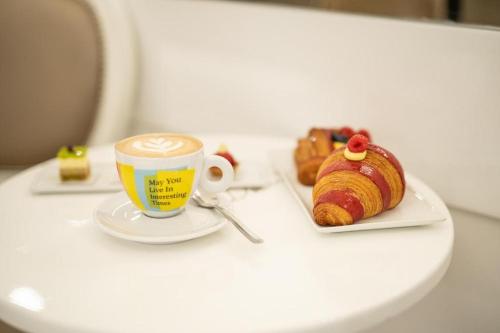 a cup of coffee and a croissant on a table at La Malva - L'Opera Group in La Spezia
