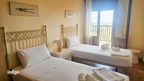 Dos camas en una habitación con ventana. en Impresionates vistas, 2 Dormitorios JUL01, en Ayamonte