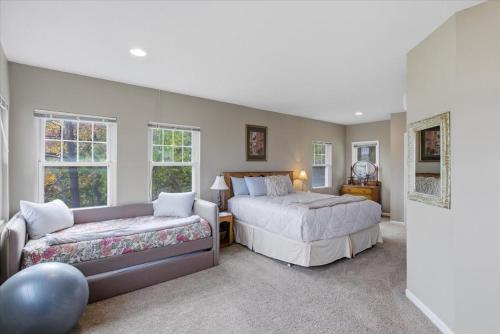 een slaapkamer met 2 bedden en een bank bij Lakefront Home w/ Double Deck, Slip, Firepit & Game Room in Sunrise Beach