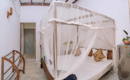 un dormitorio con una cama con mosquitera en Stay Salty, en Matara