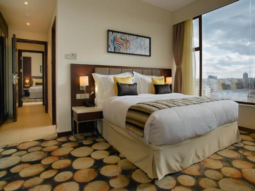 a bedroom with a large bed and a large window at The Concord Hotel & Suites in Nairobi