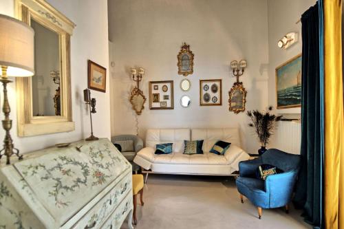 a living room with a white couch and a blue chair at Tenuta Lonciano in Gualdo