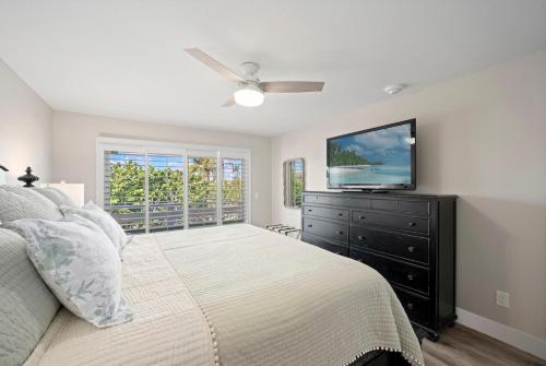 a bedroom with a bed and a flat screen tv at Surfside 12 A4 in Sanibel
