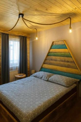 a bedroom with a large bed with a wooden ceiling at Chatka Wagabundy in Wola Michowa