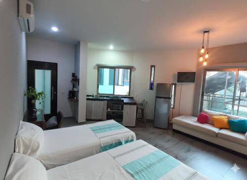 een slaapkamer met 2 bedden en een keuken met een wastafel bij Casa Arbol de Paz in Chacala