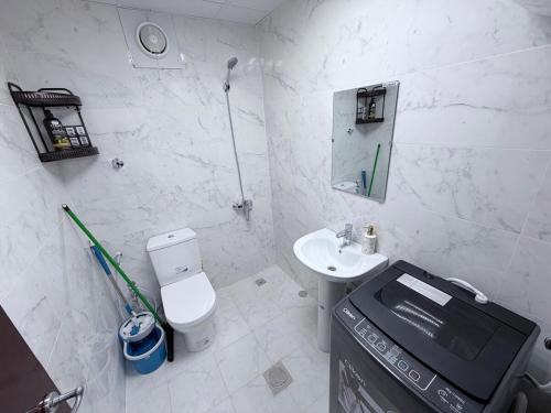 biała łazienka z toaletą i umywalką w obiekcie Studio M4 w Abu Zabi