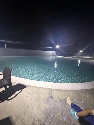 una piscina de noche con una persona tumbada en una silla en Comfort and tranquility in one place, en La Estrella