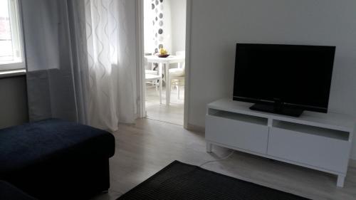 a living room with a flat screen tv on a white cabinet at Apartment Vuorikatu 35 in Kuopio