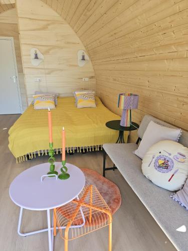 a small room with a bed and a table at Tiny House De Hagekrûper in Westergeest