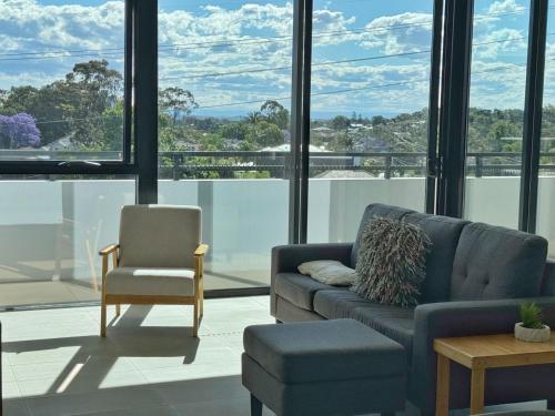 a living room with a couch and a chair at Luxury 2BR Stay near Olympic Park Parramatta FREE Parking in Sydney