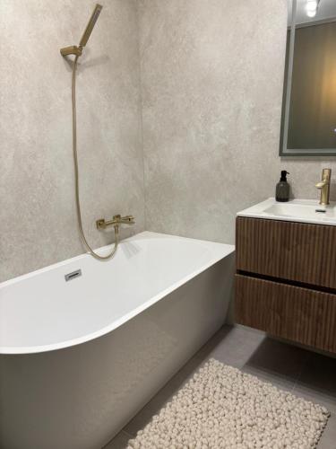 a bathroom with a white bath tub and a sink at HelloWine Apartman in Eger