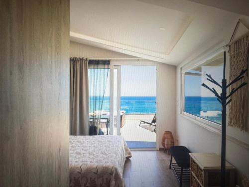 a room with a bedroom with a view of the ocean at Sea waves suite in Hersonissos