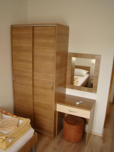 a bathroom with a wooden cabinet and a mirror at Pansion Ivan in Međugorje