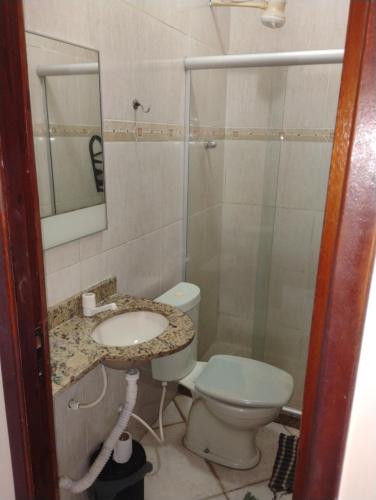 Un baño con inodoro, lavabo y ducha. en Pousada Pé na Praia, en Rio das Ostras