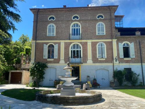 a fountain in front of a large brick building at Io&Te La Suite di Villa Monteriolo in Canelli