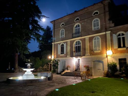 a building with a fountain in front of it at night at Io&Te La Suite di Villa Monteriolo in Canelli