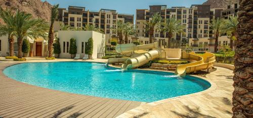 ein Schwimmbad mit Rutsche in einem Resort in der Unterkunft Al RAHA village - Aqaba أستوديو بقرية الراحه العقبة مرسى زايد in Aqaba