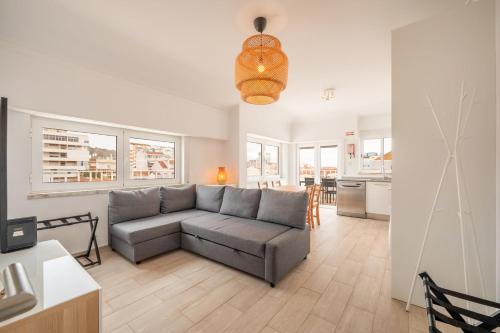 a living room with a couch and a kitchen at GuestReady - Sunny Retreat in Costa da Caparica in Costa da Caparica
