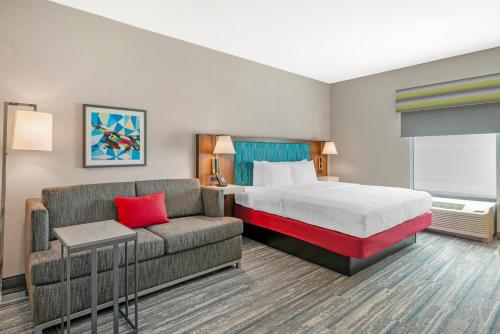 a hotel room with a bed and a couch at Hampton Inn Junction City in Junction City