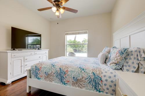 ein Schlafzimmer mit einem Bett und einer Kommode mit einem Fernseher in der Unterkunft Outdoor Kitchen and Patio Loxahatchee Oasis! in Royal Palm Beach