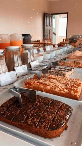Un montón de diferentes tipos de postres en exhibición. en Pousada da Praia, en Garopaba