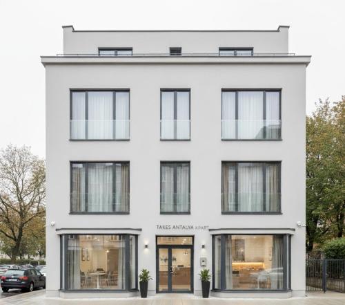 een wit gebouw met glazen ramen bij Takes Antalya Apart in Antalya