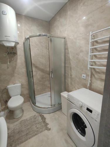 ein Badezimmer mit Waschmaschine und Toilette in der Unterkunft New Comfort Apartment in Hostomelʼ