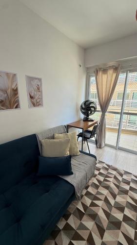 a living room with a blue couch and a table at Beach Place ACONCHEGO e refúgio perto do mar in Cumbuco